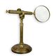 A BRASS MAGNIFYING-GLASS ON A STAND
