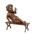 A BRONZE SCULPTURE OF A CHILD WITH BIRD ON BENCH
