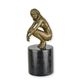 A BRONZE SCULPTURE OF A COWERING NUDE