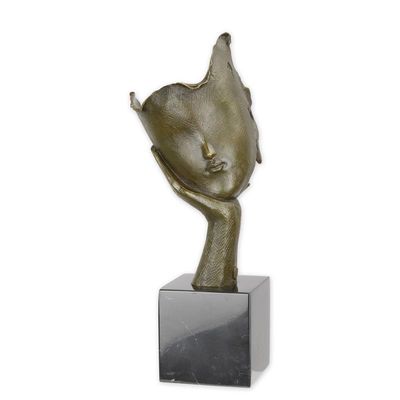 A BRONZE SCULPTURE OF A FACE RESTING ON HAND PALM