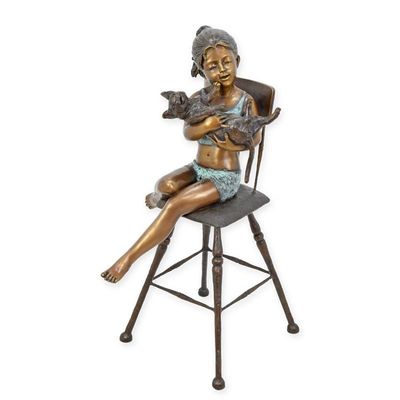 A BRONZE SCULPTURE OF A GIRL AND CAT SITTING ON A CHAIR