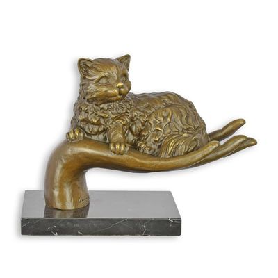 A BRONZE SCULPTURE OF A HAND HOLDING A CAT