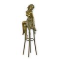 A BRONZE SCULPTURE OF A LADY ON BARCHAIR