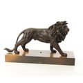 A BRONZE SCULPTURE OF A LION MOUNTED ON A WOODEN PLANK