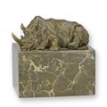 A BRONZE SCULPTURE OF A LYING RHINOCEROS