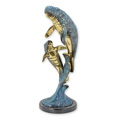 A BRONZE SCULPTURE OF A MANATEE WITH YOUNG
