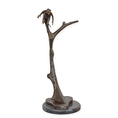 A BRONZE SCULPTURE OF A MONKEY IN TREE