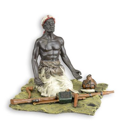 A BRONZE SCULPTURE OF A SEATED ARMS DEALER
