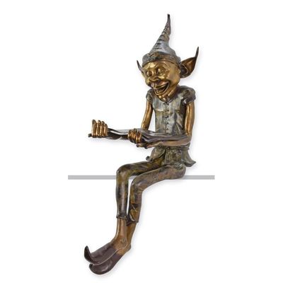 A BRONZE SCULPTURE OF A SITTING GOBLIN WITH A BOOK