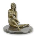 A BRONZE SCULPTURE OF A SITTING NUDE