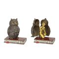A BRONZE SCULPTURE OF A WOMAN AND OWL ON BOOKS
