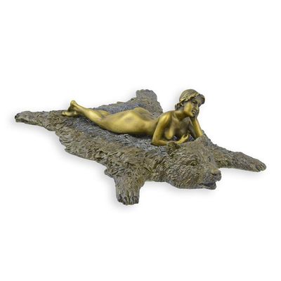 A BRONZE SCULPTURE OF A WOMAN ON A BEAR SKIN