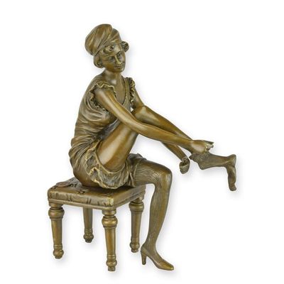 A BRONZE SCULPTURE OF A WOMAN PUTTING ON PANTIES