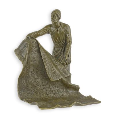 A BRONZE SCULPTURE OF AN ARAB CARPET SELLER