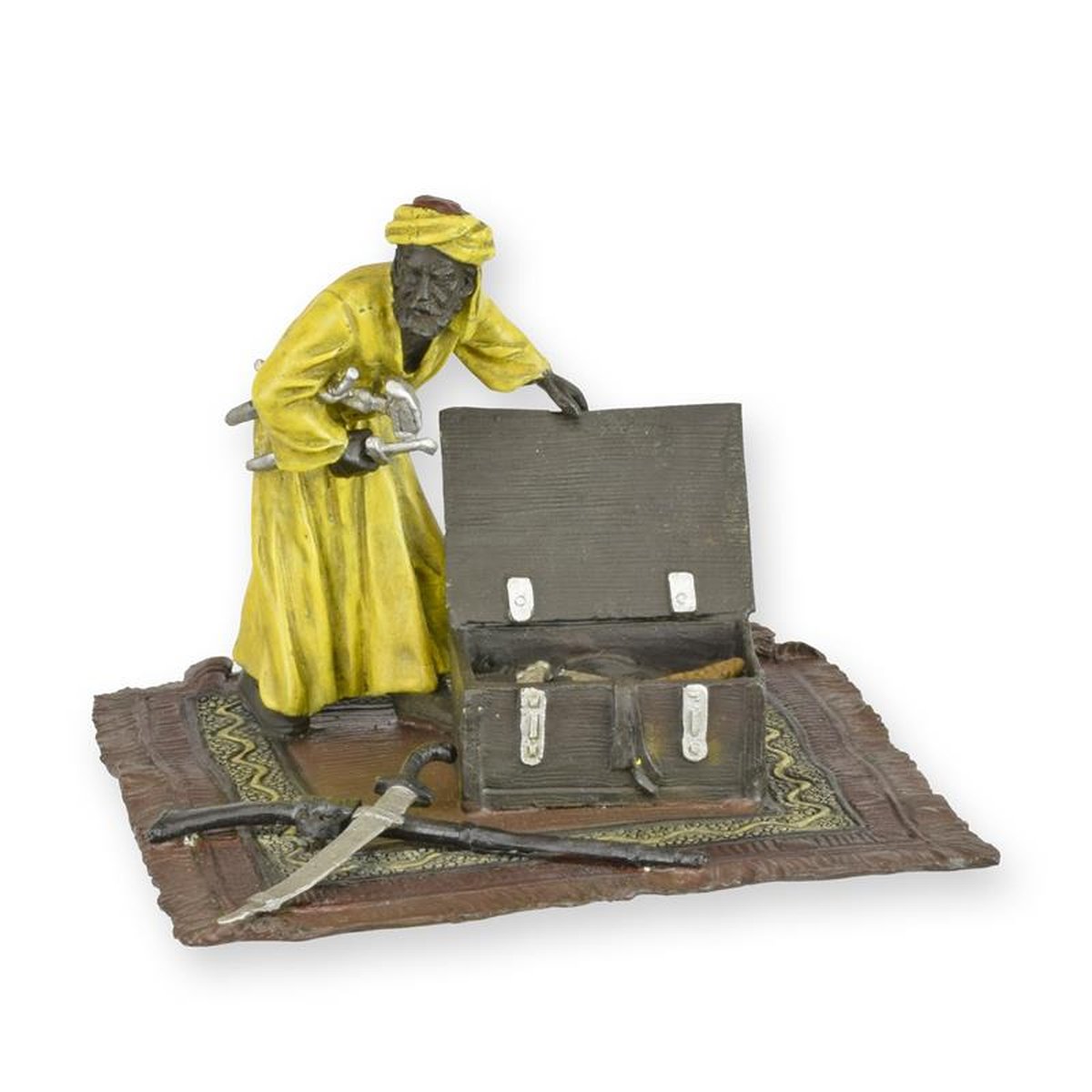 A BRONZE SCULPTURE OF AN ARAB ON A CARPET WITH WEAPON CHEST