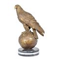 A BRONZE SCULPTURE OF AN EAGLE SITTING ON GLOBE