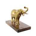 A BRONZE SCULPTURE OF AN ELEPHANT MOUNTED ON A WOODEN PLANK
