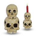 A CAST IRON DOUBLE SKULL CANDLE HOLDER