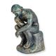 A CAST IRON FIGURINE OF THE THINKER - ANTIQUE GREEN