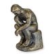 A CAST IRON FIGURINE OF THE THINKER - BRONZE COLOURED