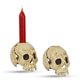 A CAST IRON SKULL CANDLE HOLDER, OLD WHITE