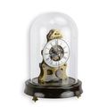 A MECHANICAL TABLE CLOCK UNDER GLASS DOME