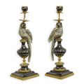 A PAIR OF BRONZE MOUNTED PORCELAIN PARROT CANDLE HOLDERS