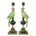 A PAIR OF BRONZE MOUNTED PORCELAIN PARROT CANDLE HOLDERS
