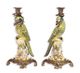 A PAIR OF BRONZE MOUNTED PORCELAIN PARROT CANDLE HOLDERS