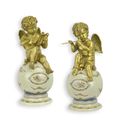 A PAIR OF BRONZE PUTTI ON PORCELAIN BALL