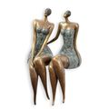 A PAIR OF BRONZE SITTING WOMEN