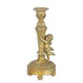 A RESIN CANDLE-STICK MOUNTED WITH A PUTTO