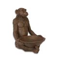 A RESIN FIGURINE OF A SEATED MONKEY WITH FRUITBOWL