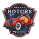 AN EMBOSSED TIN PLATE - DELUXE MOTORS